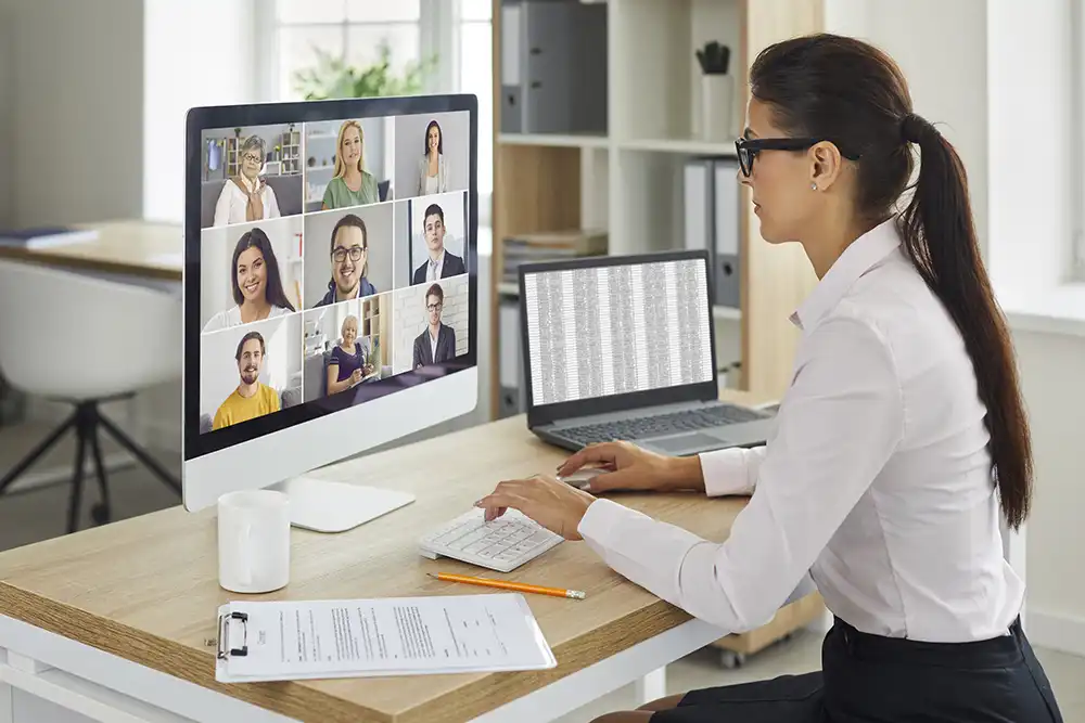 Woman in Front of computer clapping hands sharing virtual meeting